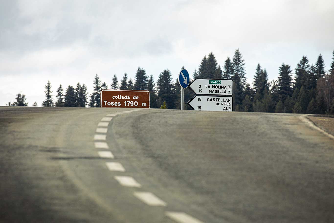 Mountain pass road at Collada de Toses, 1,790 meters high, with direction signs pointing to La Molina, Masella, Castellar de n’Hug and Alp.